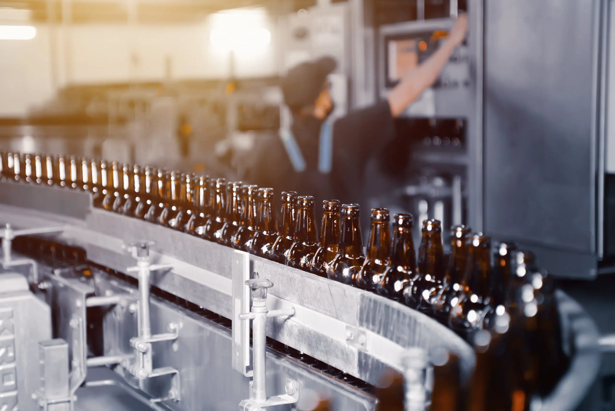 Bouteilles de bière en verre de couleur marron sur la ligne de convoyage de gros plan de la mise en bouteille de bière
