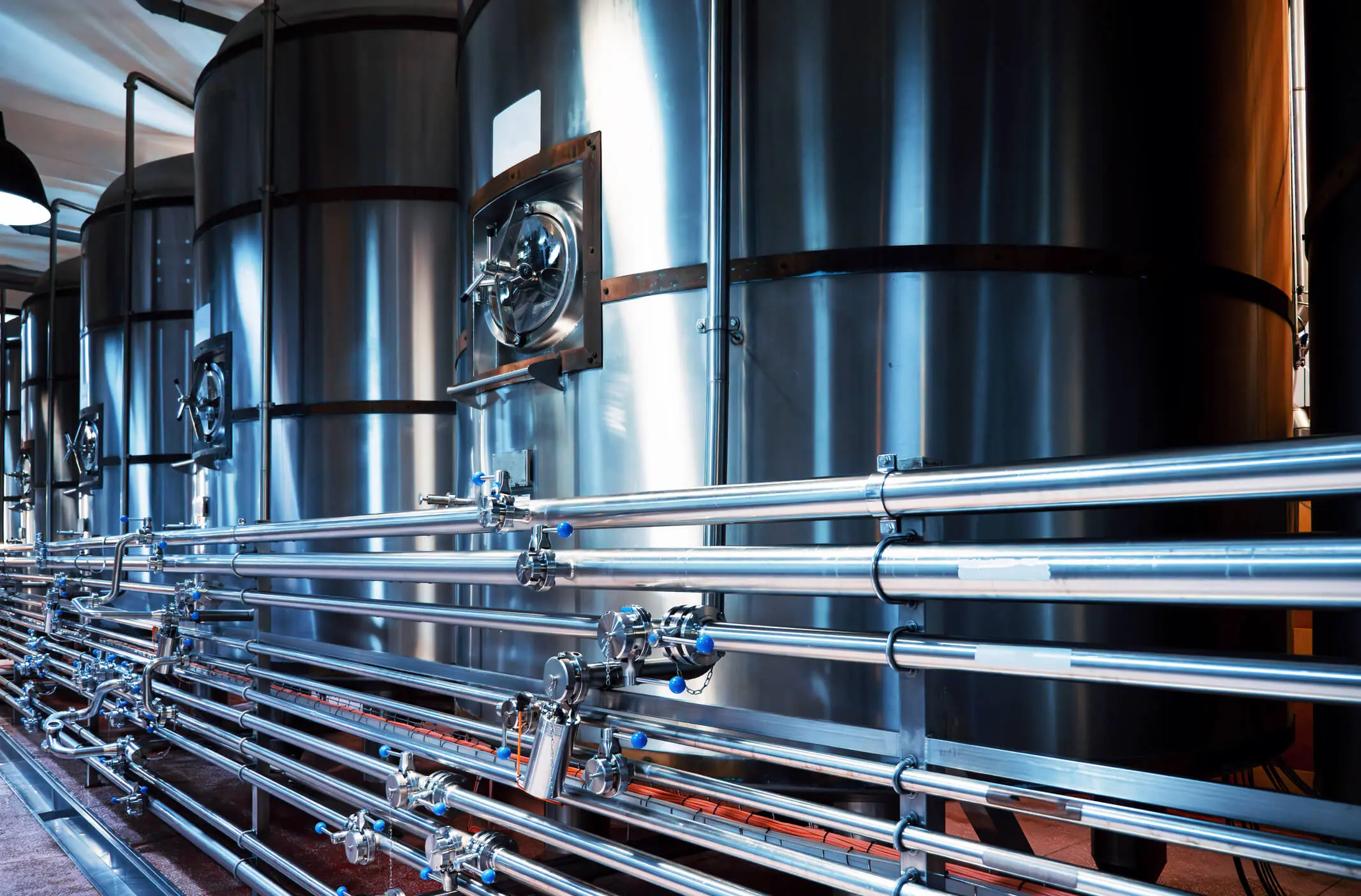 Cuves en acier de brasserie modernes et tuyauterie complexe, précision et qualité dans la production de bière artisanale.